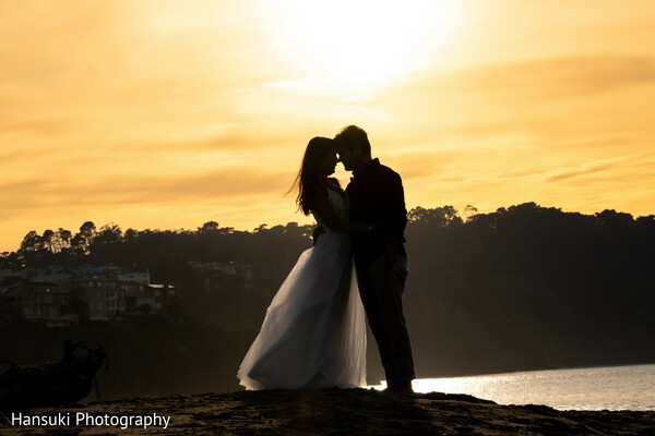 sunset wedding kiss,cinematic couple silhouette,beach love photo,romantic indian wedding moment,golden hour love,wedding photography goals,silhouette photo magic,bride groom sunset pose,warm sky romance,timeless wedding kiss