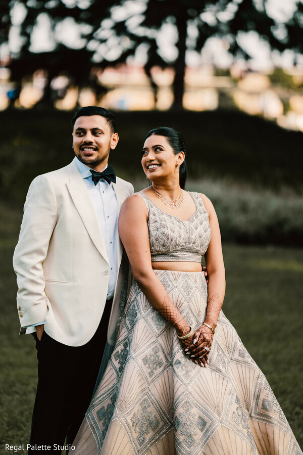 couple formal portrait,glamorous bride groom photo,outdoor wedding elegance,sparkly bridal gown,indian groom tuxedo,stylish south asian couple,luxury wedding fashion,love under golden light,outdoor reception portrait,bride groom style