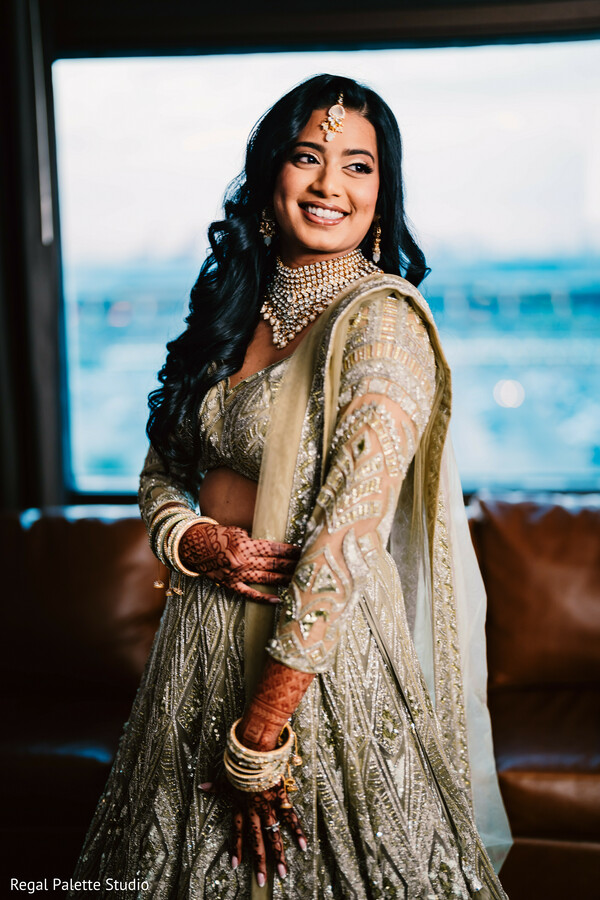bride by window,city view bridal photo,shimmering lehenga look,south asian bride fashion,indoor bridal portrait,bridal glow image,urban wedding elegance,solo bride modern look,indian wedding outfit glam,city wedding vibe