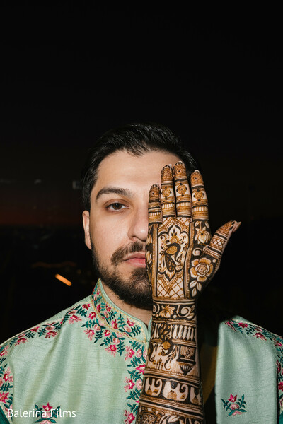 groom mehndi,groom portrait,creative wedding photo,mint kurta,floral embroidery,bold henna design,south asian groom style,artistic wedding shot,mehndi for men,modern groom fashion