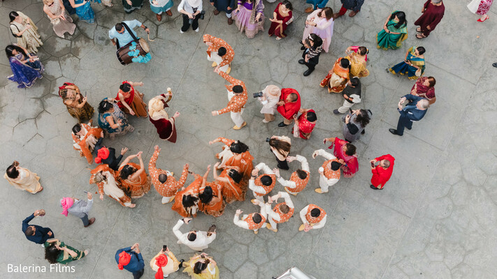 baraat celebration,aerial wedding shot,indian groom procession,dancing guests,joyful wedding,wedding from above,colorful wedding traditions,south asian culture,pre-wedding festivities,courtyard baraat