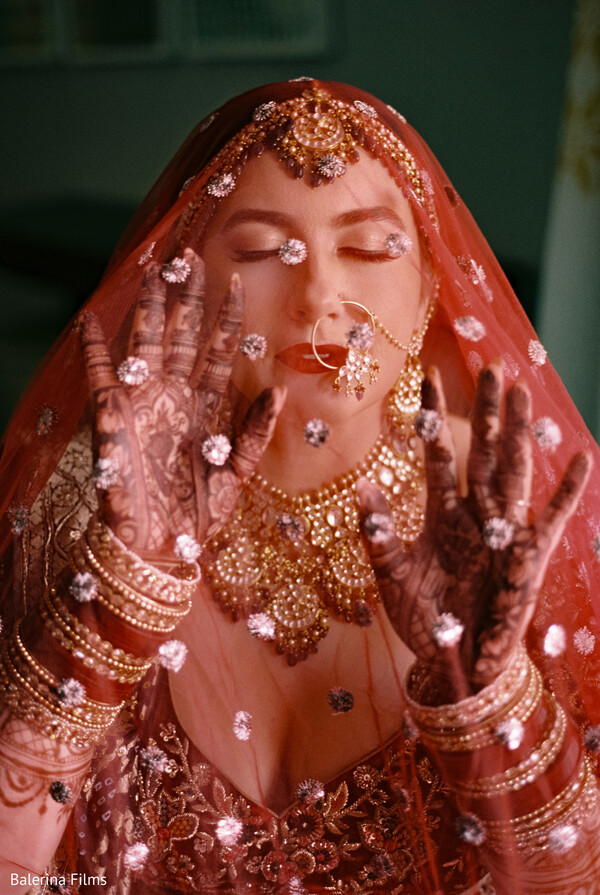 bridal portrait,red bridal dupatta,mehndi on hands,dreamy wedding photo,south asian bride,gold bridal jewelry,intimate bridal moment,artistic veil shot,traditional indian wedding,emotional bride photo
