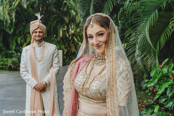 outdoor first look,bridal portrait,groom sherwani,lehenga with veil,hindu wedding style,indian bride,natural greenery,soft glam bride,romantic moment,wedding couple elegance