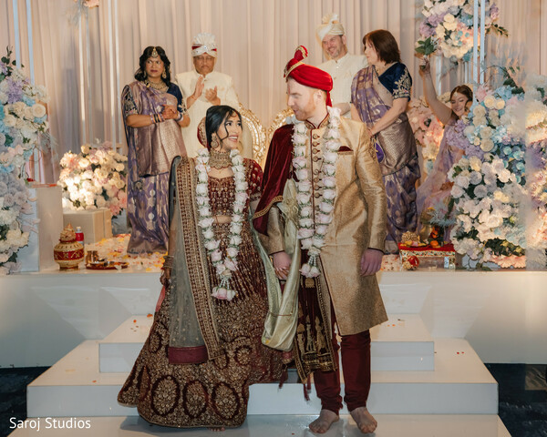 indian wedding stage,bride and groom walk,pastel wedding decor,cultural wedding ceremony,indian wedding photography,traditional wedding attire,floral mandap decor,walking down mandap,wedding couple portrait,elegant wedding setup