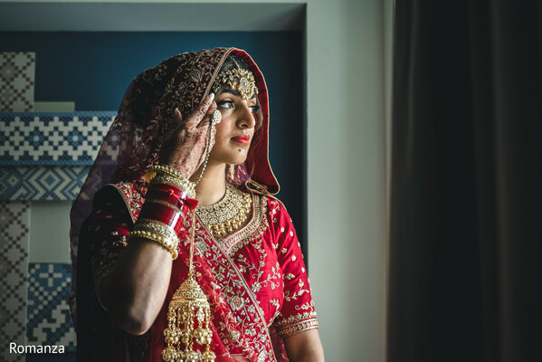 ridal prep moment,window light portrait,red bridal lehenga,thoughtful bride,emotional wedding moment,indian wedding,romanza photography,bridal beauty