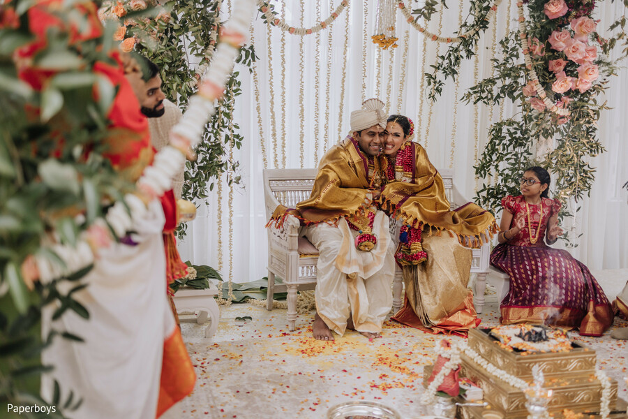 petal shower,wedding joy,hindu ceremony,bride and groom,floral decor,south asian wedding,celebration moment,indian traditions,colorful mandap,newlyweds