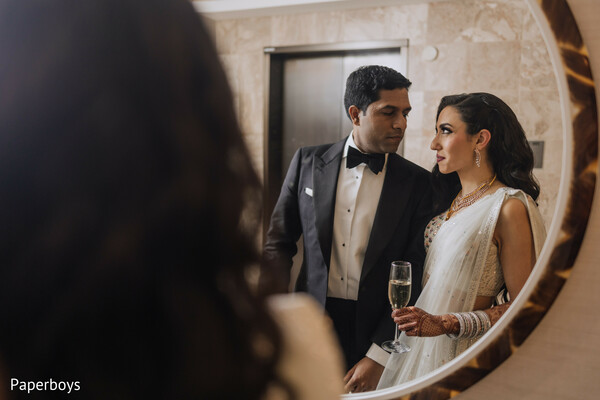 bride and groom,mirror shot,candid couple,champagne toast,reception prep,elegant attire,evening look,romantic moment,black tie wedding,indian couple
