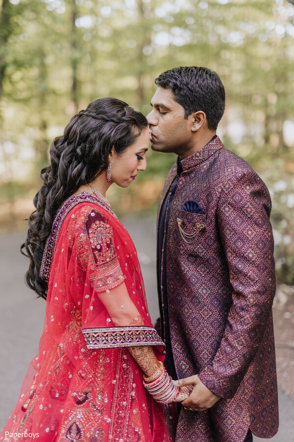 forehead kiss,romantic moment,bridal red outfit,groom sherwani,couple portrait,indian wedding,love in the air,outdoor shoot,wedding fashion,emotional connection