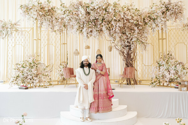 wedding stage,floral setup,bride and groom,ceremony entrance,wedding elegance,luxury indian wedding,mandap decor,pink lehenga,traditional attire,walking together
