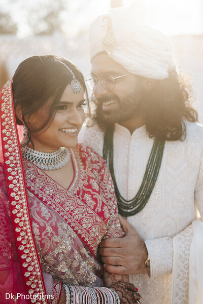 golden hour,indian couple,wedding smiles,candid moment,post-ceremony glow,bridal lehenga,wedding sherwani,joyful couple,natural light,romantic laugh