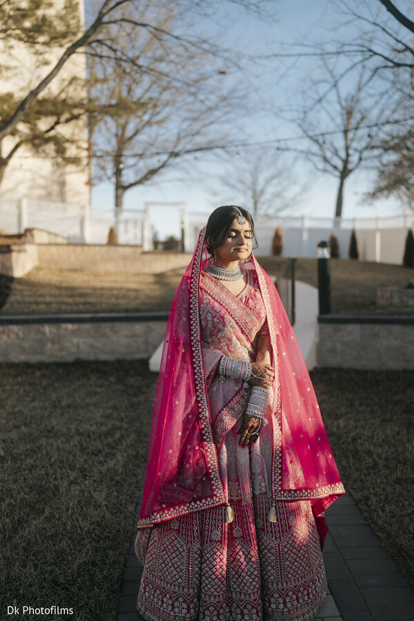 solo bridal shot,outdoor wedding,pink lehenga,winter wedding,indian bride,scenic backdrop,contrast composition,bridal style,nature and fashion,powerful pose