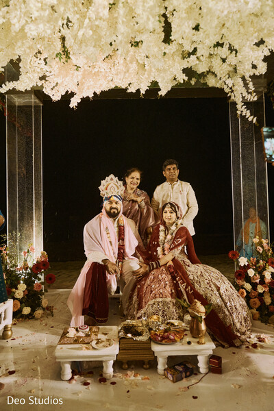 wedding ceremony,floral canopy,indian bride and groom,sacred rituals,mandap decor,indian traditions,cultural wedding,floral arch,spiritual moment,regal elegance