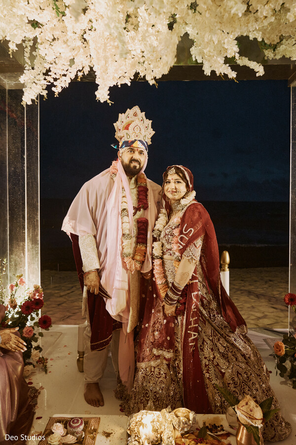beach ceremony,floral mandap,indian wedding vows,sunset wedding,romantic ritual,wedding by the water,south asian ceremony,wedding decor,sacred love,dusky glow