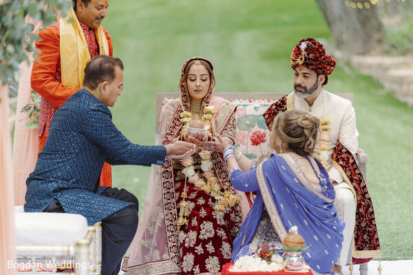 indian wedding pheras,bride and groom walking,floral mandap ceremony,pink draped mandap,traditional hindu wedding,wedding garlands,sacred wedding ritual,couple during vows,wedding ceremony details,romantic indian traditions