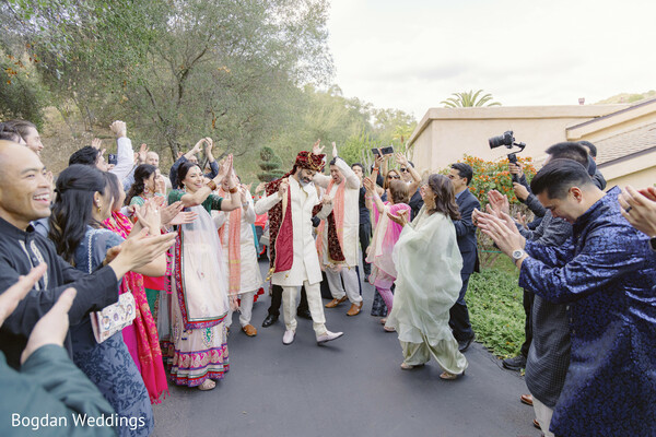 indian groom baraat,dancing groom,wedding procession celebration,groom arrival,baraat celebration,joyous indian wedding,wedding guests dancing,outdoor baraat,festive groom entry,groom in red turban
