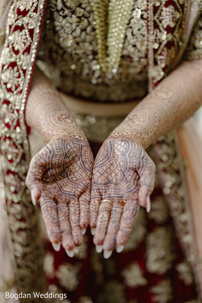 bridal mehndi design,henna close-up,intricate hand mehndi,indian bridal details,bride hands photo,red and gold lehenga,mehndi artistry,wedding tradition,cultural wedding detail,bridal look focus