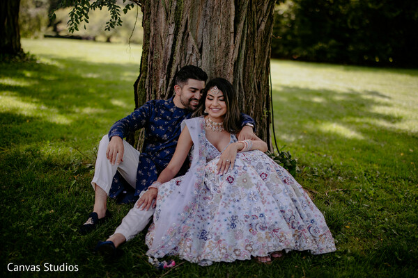 pastel outfit,floral dress,tree shade,candid couple moment,engagement shoot,outdoor session,romantic cuddles,bride and groom prewedding,summer vibes,grassy love scene