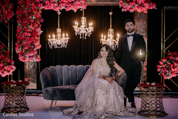 first dance,wedding reception,emotional moment,bridal gown,black tuxedo groom,romantic lighting,desi couple,chandelier decor,tender embrace,dance floor moment