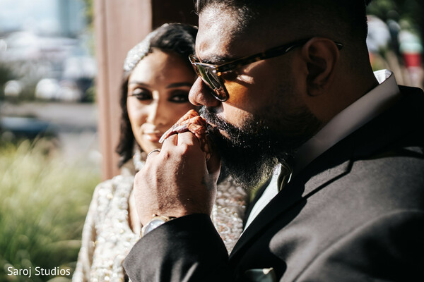 candid groom portrait,groom sunglasses style,bride looking at groom,modern wedding couple,black suit groom,silver gown bride,outdoor wedding moment,stylish groom look,wedding day fashion,romantic candid shot