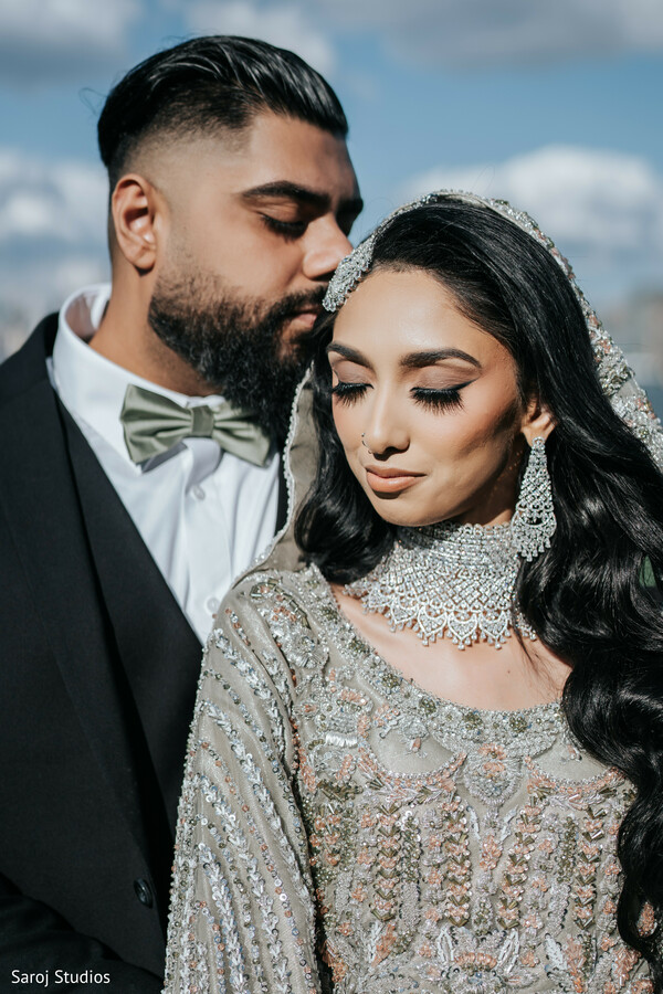 romantic couple pose,silver bridal dress,black groom suit,blue sky wedding photo,outdoor couple portrait,elegant wedding attire,stylish couple photography,intimate love shot,destination wedding vibe,chic wedding look