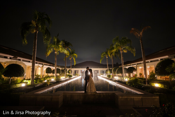 night wedding,romantic silhouette,water feature wedding,palm tree venue,luxury wedding,dramatic wedding photo,destination wedding,cinematic romance,wedding reflections,evening elegance