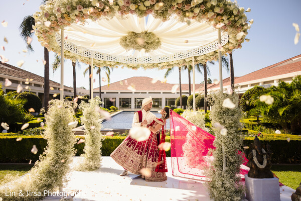 wedding mandap,floral canopy,indian wedding rituals,wedding ceremony,flower shower,pheras tradition,sacred vows,south asian wedding decor,palm tree venue wedding,cultural celebration