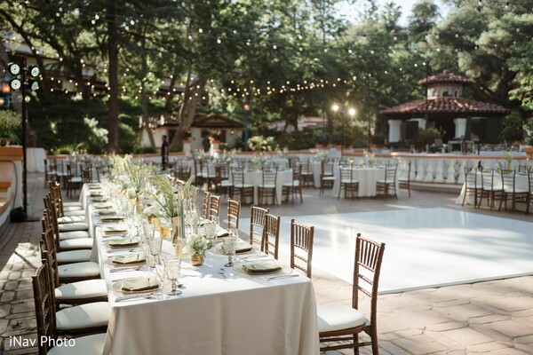 outdoor wedding reception,banquet tables,elegant tablescape,wedding decor,string lights,white table setting,rustic chic wedding,dance floor setup,nature wedding venue,romantic ambiance