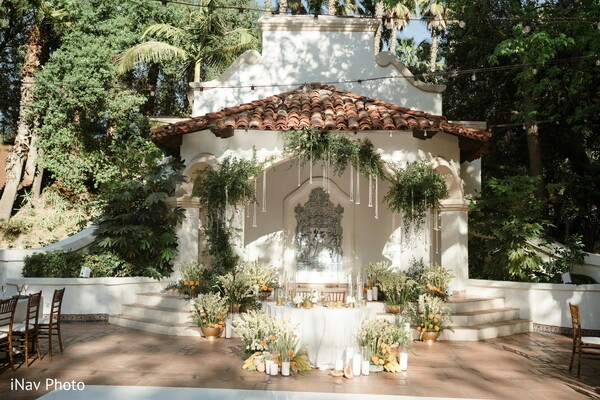 outdoor altar,spanish-style venue,wedding greenery decor,floral backdrop,rustic romance,intimate wedding altar,garden ceremony,boho chic wedding,greenery wedding design,wedding stage setup