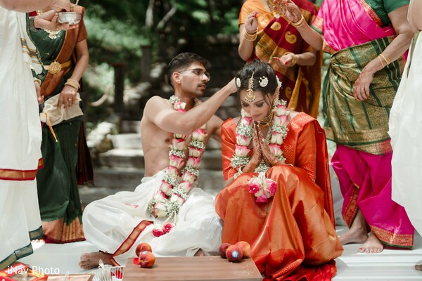 hindu wedding traditions,bride in red saree,cultural wedding rituals,family wedding moment,vibrant indian ceremony,sacred wedding customs,emotional rituals,traditional attire,candid wedding ceremony,south asian bride