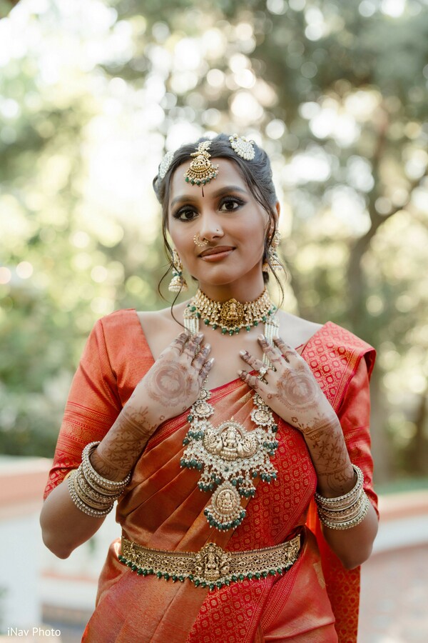 bridal portrait,bride in red saree,statement wedding jewelry,traditional bridal look,south asian bride,elegant bridal pose,outdoor bridal shot,cultural wedding fashion,indian bridal attire,regal bride style
