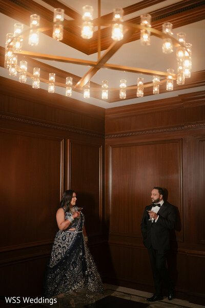 indoor couple portrait,chandelier wedding photo,navy evening gown bride,groom in tuxedo,elegant reception moment,glamorous south asian couple,luxury wedding lighting,romantic evening portrait,intimate wedding photography,timeless couple elegance