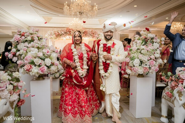 bride with bridesmaids,joyful wedding moment,red bridal lehenga,colorful bridesmaid outfits,cultural wedding traditions,candid bridal laughter,pre-wedding celebration,south asian wedding joy,vibrant wedding photography,friendship wedding moment