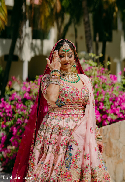 bride portrait,pastel lehenga,bridal jewelry,floral background,south asian bride,wedding attire,pink dupatta,elegant bride,outdoor bridal shot,wedding details