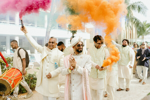 baraat procession,groom entrance,smoke bombs,indian groom,wedding celebration,festive vibes,wedding party,south asian wedding,white outfits,colorful wedding