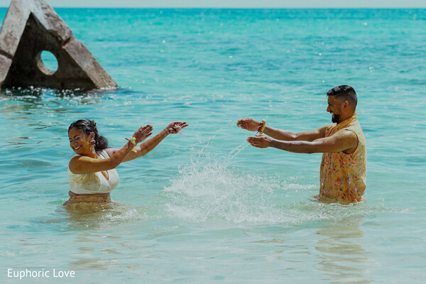 beach couple,playful wedding photo,water splash,candid bride and groom,ocean romance,tropical wedding,destination wedding,carefree couple,seaside love,wedding fun