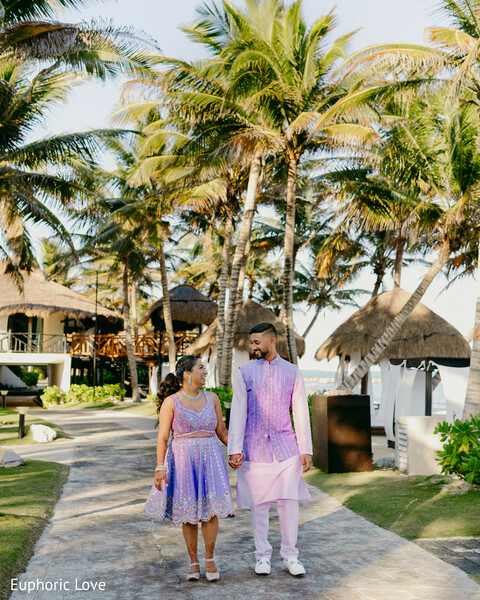 couple walk,pastel outfits,outdoor romance,tropical wedding,candid bride and groom,palm tree background,destination love,south asian couple,hand-in-hand,wedding stroll
