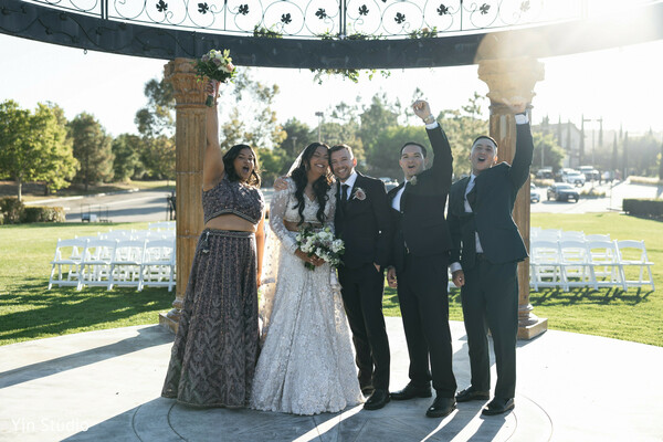 outdoor reception,wedding guests,group happiness,joyful moment,cultural blend,sunny wedding,celebration captured,smiling faces,wedding portraits,timeless joy