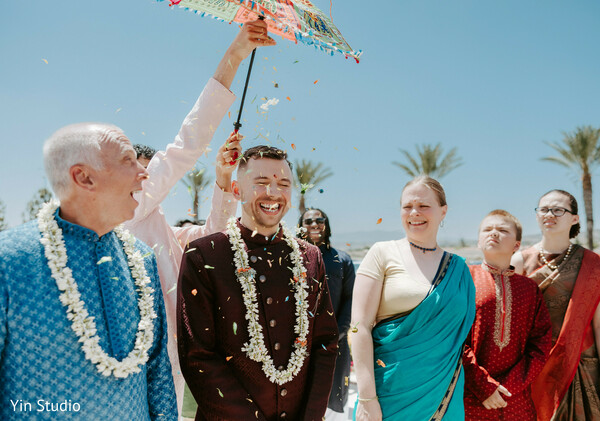 flower shower,groom celebration,joyful wedding,candid moment,indian traditions,happiness captured,outdoor wedding,smiling guests,festive colors,sacred rituals