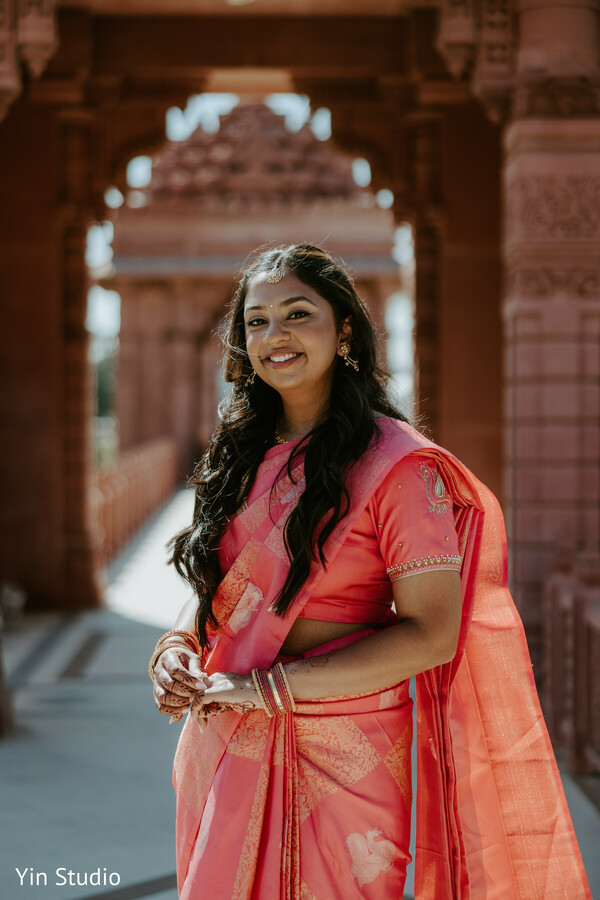 bride portrait,pink saree,bridal elegance,indian wedding,temple arch,glowing bride,candid smile,traditional attire,bridal jewelry,chino hills wedding