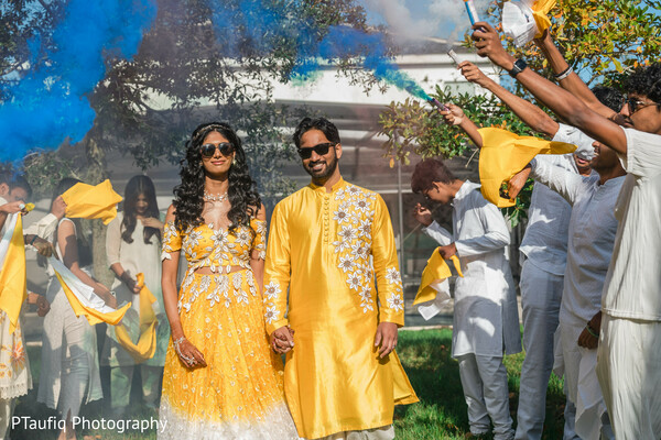 haldi entrance,smoke bomb wedding photo,yellow couple outfits,fun pre-wedding celebration,indian wedding ceremony,outdoor wedding vibe,colorful south asian moment,sunglasses couple,wedding group cheer,festive yellow fashion