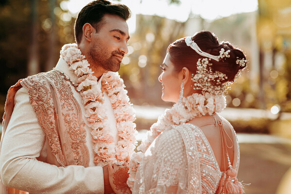 jaimala ceremony,garland exchange,wedding rituals,indian couple,outdoor ceremony,emotional moment,love in bloom,cultural tradition,timeless bond,romantic vows