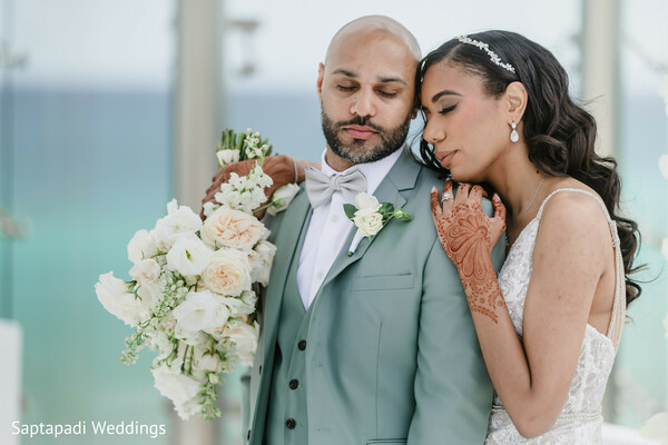 mint suit groom,oceanfront wedding,white floral bouquet,henna bride,modern wedding style,romantic couple portrait,pastel wedding theme,elegant bride and groom,destination wedding,timeless love moment