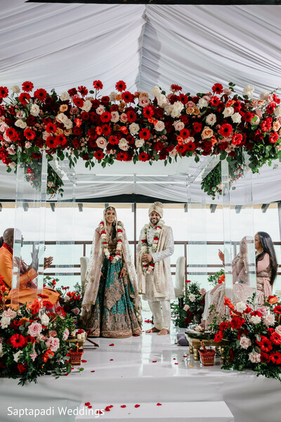 bridesmaids group,bridal party,gold saris,wedding mandap,floral decor,red and peach flowers,elegant ceremony setup,tropical wedding,indian wedding celebration,destination vows