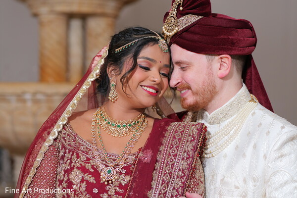 indian fusion wedding,maroon lehenga,ivory sherwani,emerald jewelry,south asian bride,multicultural couple,traditional wedding look,royal wedding attire,romantic couple portrait,bridal elegance