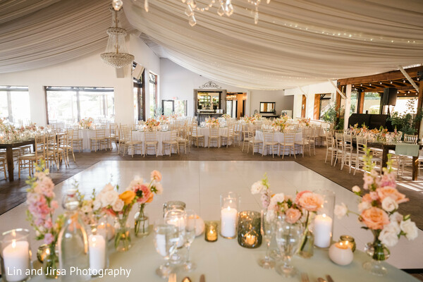 reception decor,candlelight ambiance,floral centerpieces,white draping,luxury wedding,pastel palette,gold accents,romantic setting,indoor venue,south asian reception