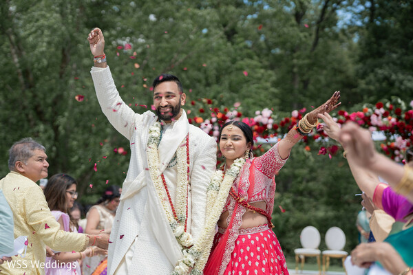 south asian couple,just married,wedding exit,ceremony celebration,floral mandap,hindu wedding,joyful moment,desi bride and groom,wedding traditions,indian ceremony joy