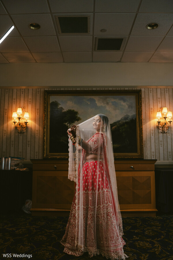 bridal portrait,wedding veil shot,south asian bride,red bridal lehenga,artistic bridal photography,indoor portrait,desi bride style,wedding day glamour,classic bridal look