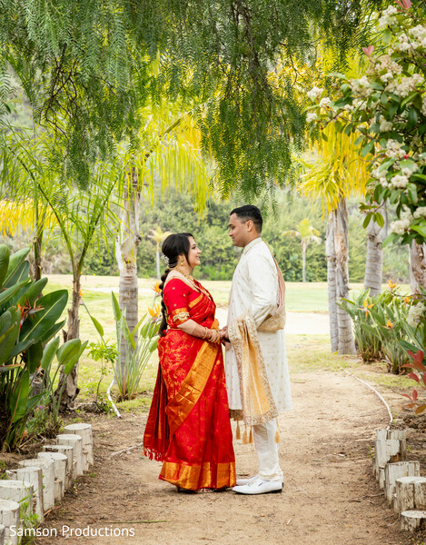 south asian couple portrait,garden wedding photos,red bridal saree,ivory sherwani,wedding attire,romantic wedding portraits