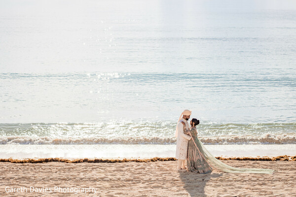 south asian destination wedding,beach wedding couple,oceanfront indian wedding,flowing bridal dupatta,seaside romance,pastel wedding attire,intimate couple portrait,tropical wedding vibes,indian bride groom,coastal wedding photography