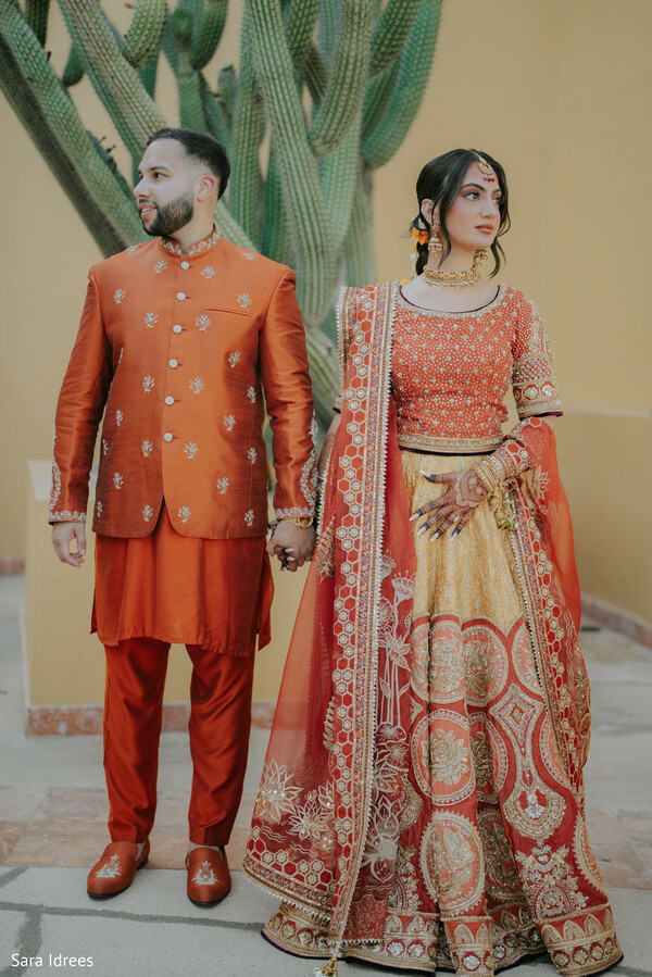 rust lehenga bride,groom in sherwani,coordinated wedding outfits,indian wedding fashion,modern traditional fusion,embroidered bridal lehenga,bold wedding colors,couple portrait,south asian couture,statement bridal look